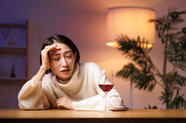 ワインを飲みすぎて二日酔いした女性