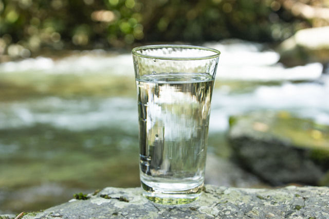 日本酒が注がれたグラスと伏流水