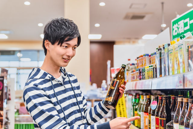 スーパーでお酒を選ぶ男性