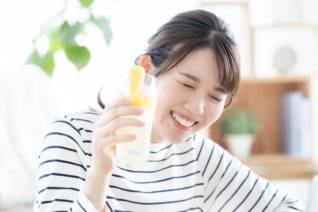 おいしそうにレモンサワーを飲む女性