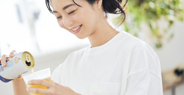 缶ビールをグラスに注ぐ女性