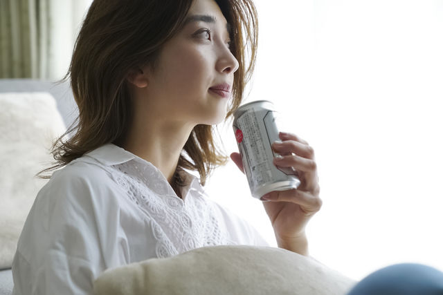 部屋でビールを飲む女性