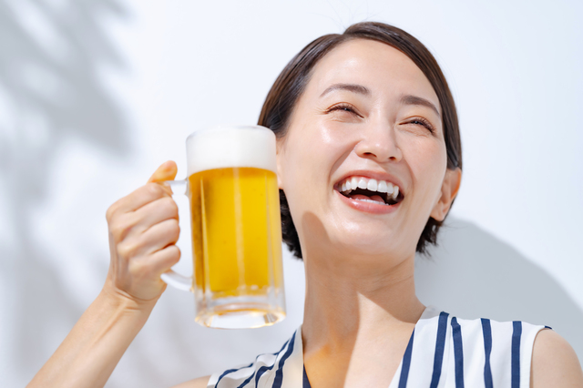 ビールジョッキを持ち上げる夏の装いの女性