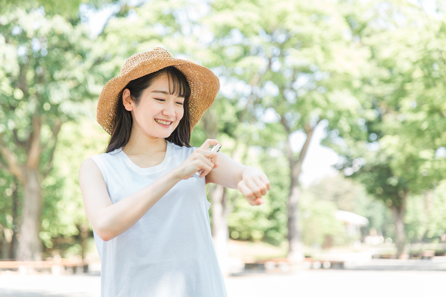 虫除けスプレーを使う若い女性